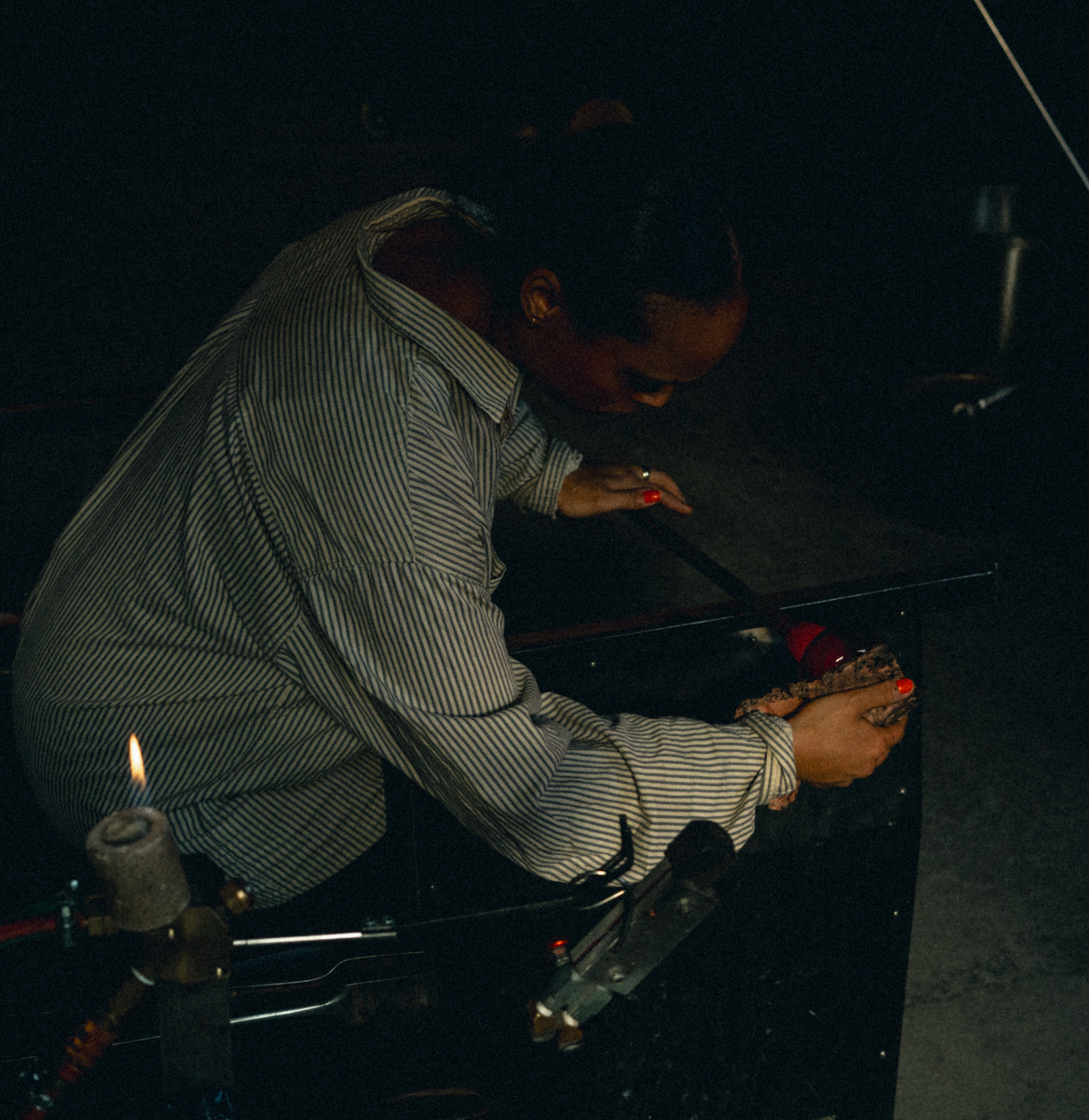 Seli working the warm glass by hand.